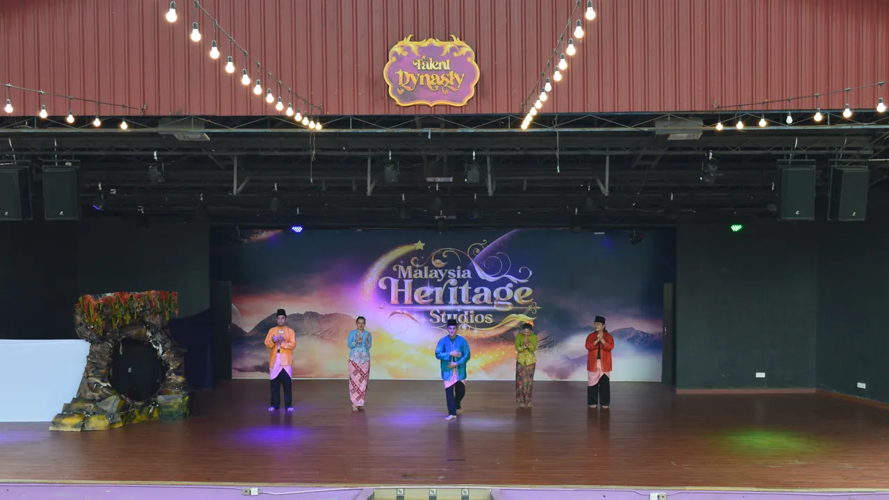 Performers in traditional Malay costume on a stage, the kind of cultural show Melaka's traditional arts theatre brings to town